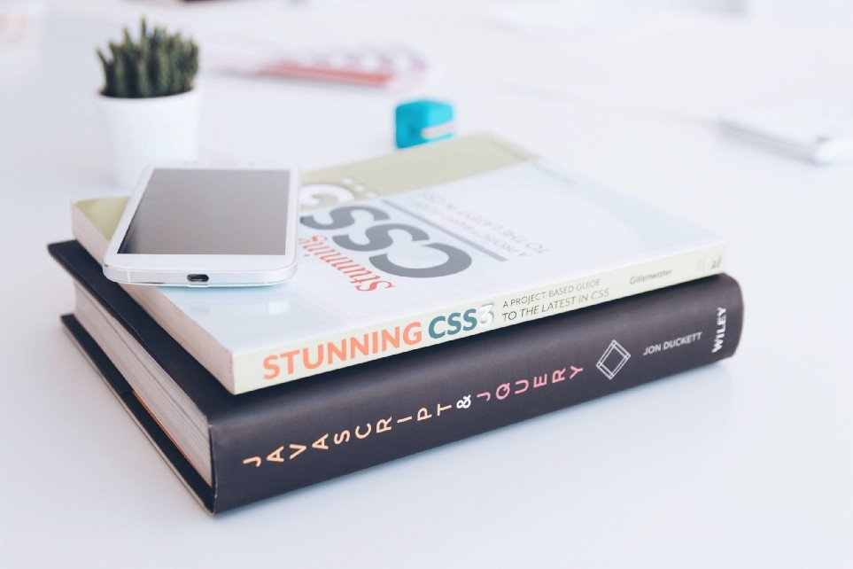 Javascript and CSS books stacked on a desk