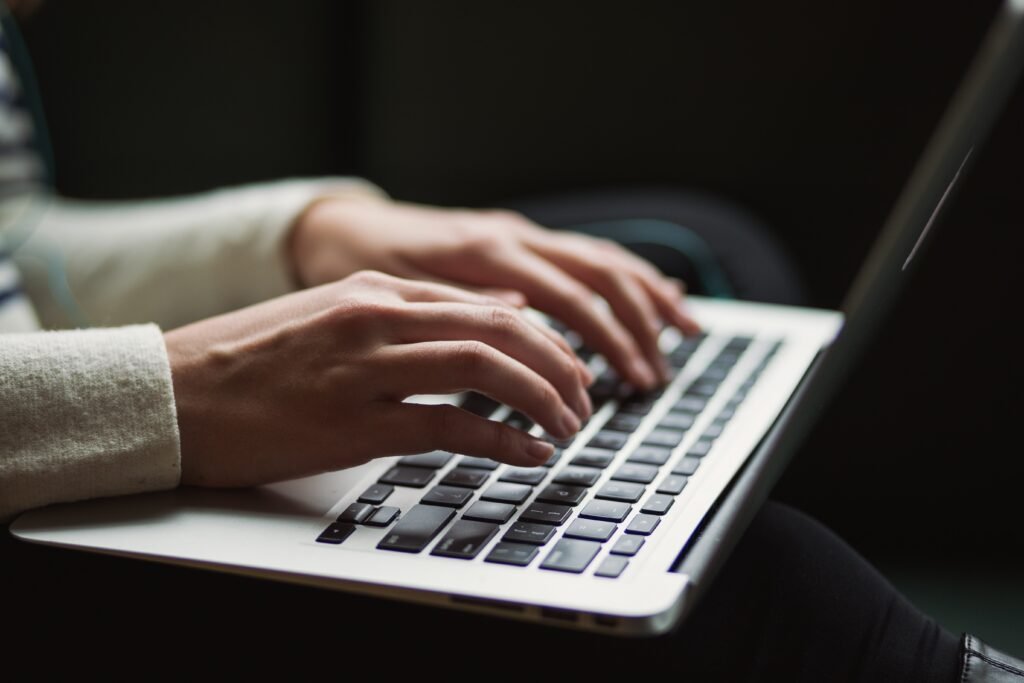 Girl writing on his macbook to describe monetization of technical posts related to open source projects