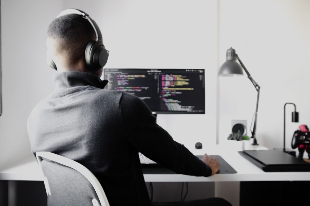 Developer sit in front of a monitor, coding JavaScript in an Open Source Project.